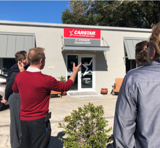 Un homme parlant à un groupe devant un emplacement de CARSTAR